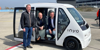 Das NeMo-Cab wird in Paderborn präsentiert. Marcus Zwick, Christoph Rüther und Thomas Tröster sitzen und lehnen sich an dem Taxi an.