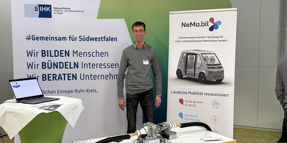 Eine Person steht vor einem Kupplungs-Demonstrator auf einer Messe.