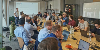 Mehrere Projektpartner sitzen an einem Tisch bei einem Treffen des NeMo.bil-Projekts