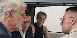 Johannes Weyer im Gespräch mit Mona Neubaur und Hendrik Wüst, die im NeMo.Cab sitzen sowie mit Jonathan Behm, der daneben steht